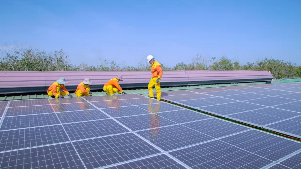 Workers installing solar panels on a building rooftop for a carpa inteligente con panel solar system.