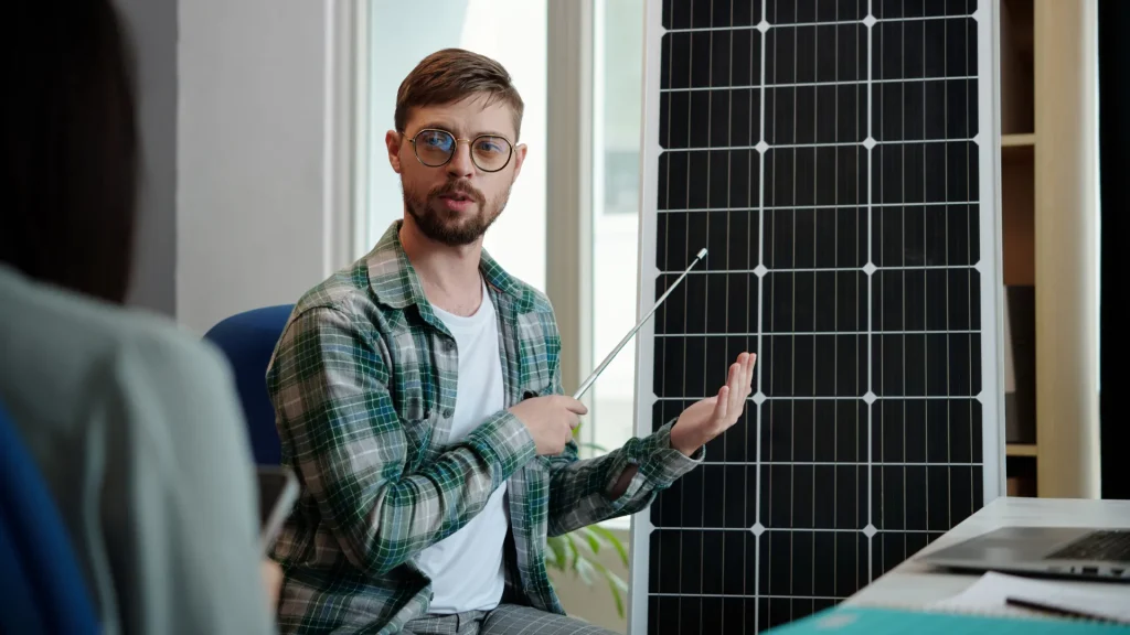 A man presenting a solar panel, explaining its integration with a Point to Point Wireless Bridge Outdoor with Solar Panel system.