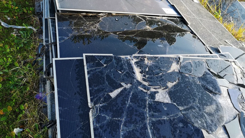 Damaged solar panels after severe breakage due to impact, showing shattered glass.