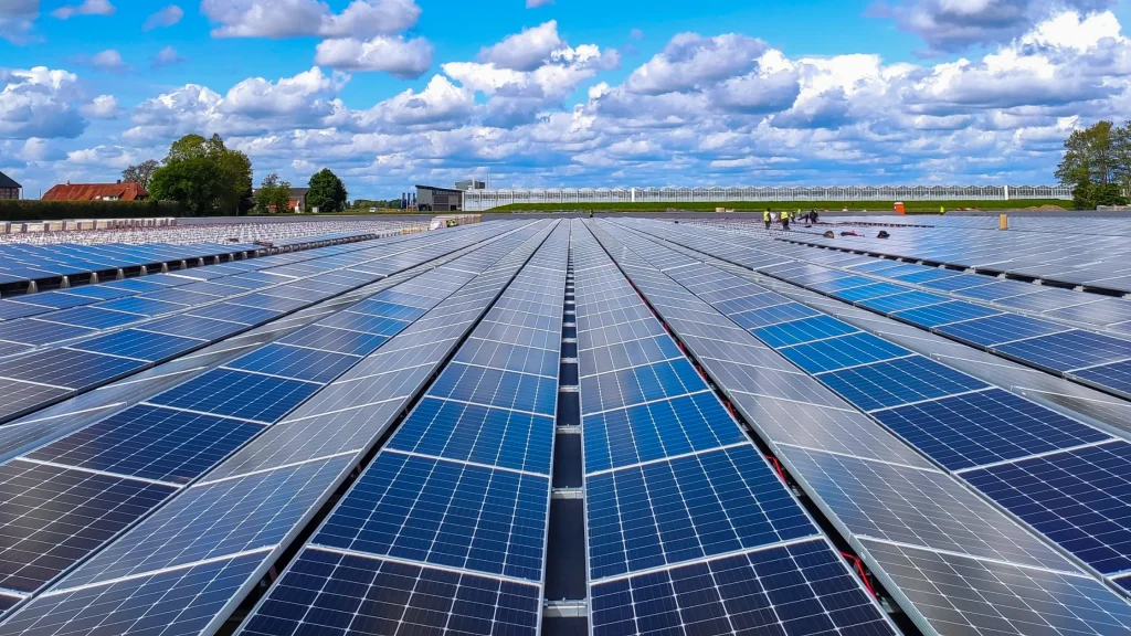 Wide array of highest wattage solar panels less than 65 inches long installed in a flat rooftop solar farm.